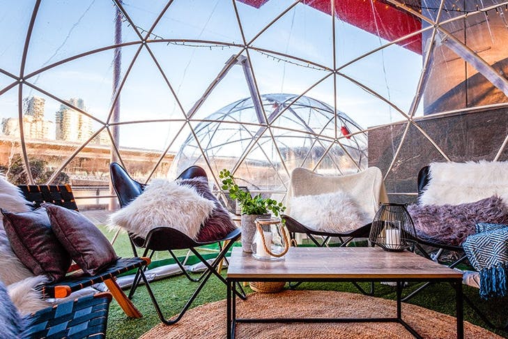 An igloo with chairs and fur rugs.